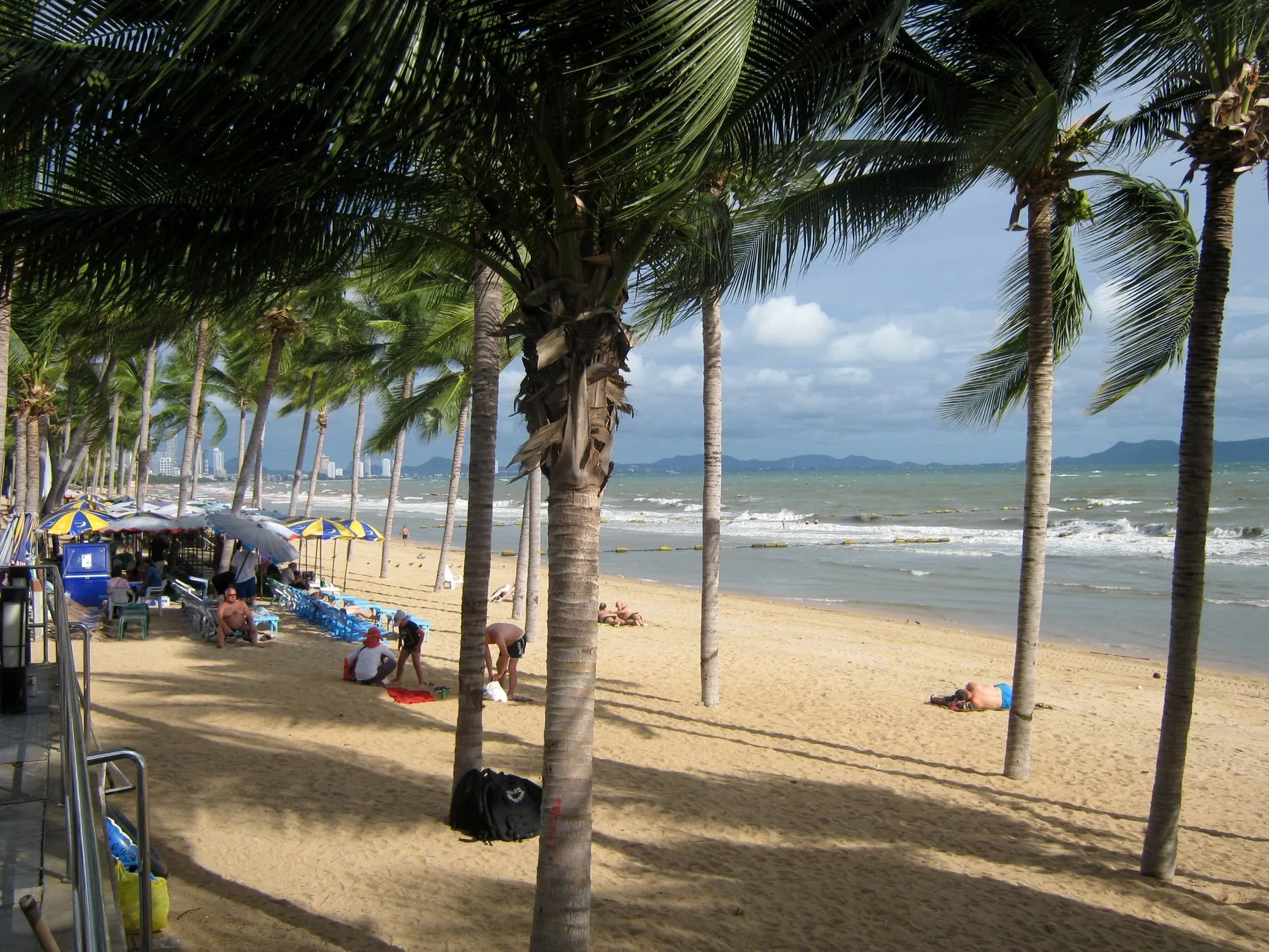 Palmer, parasoller og badegæster på Jomtien Beach