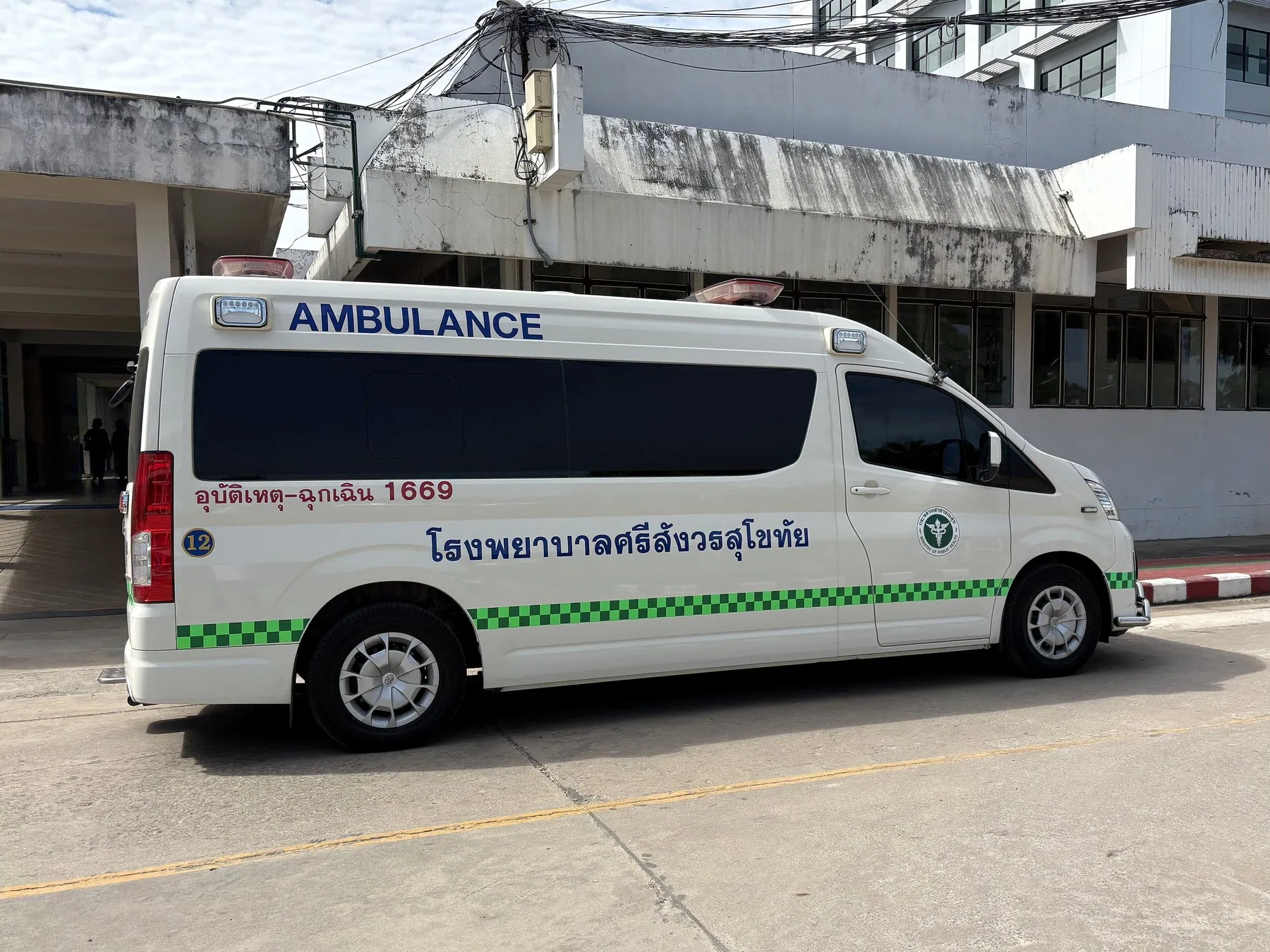 Hvid ambulance fra et thailandsk hospital parkeret ved indgangen
