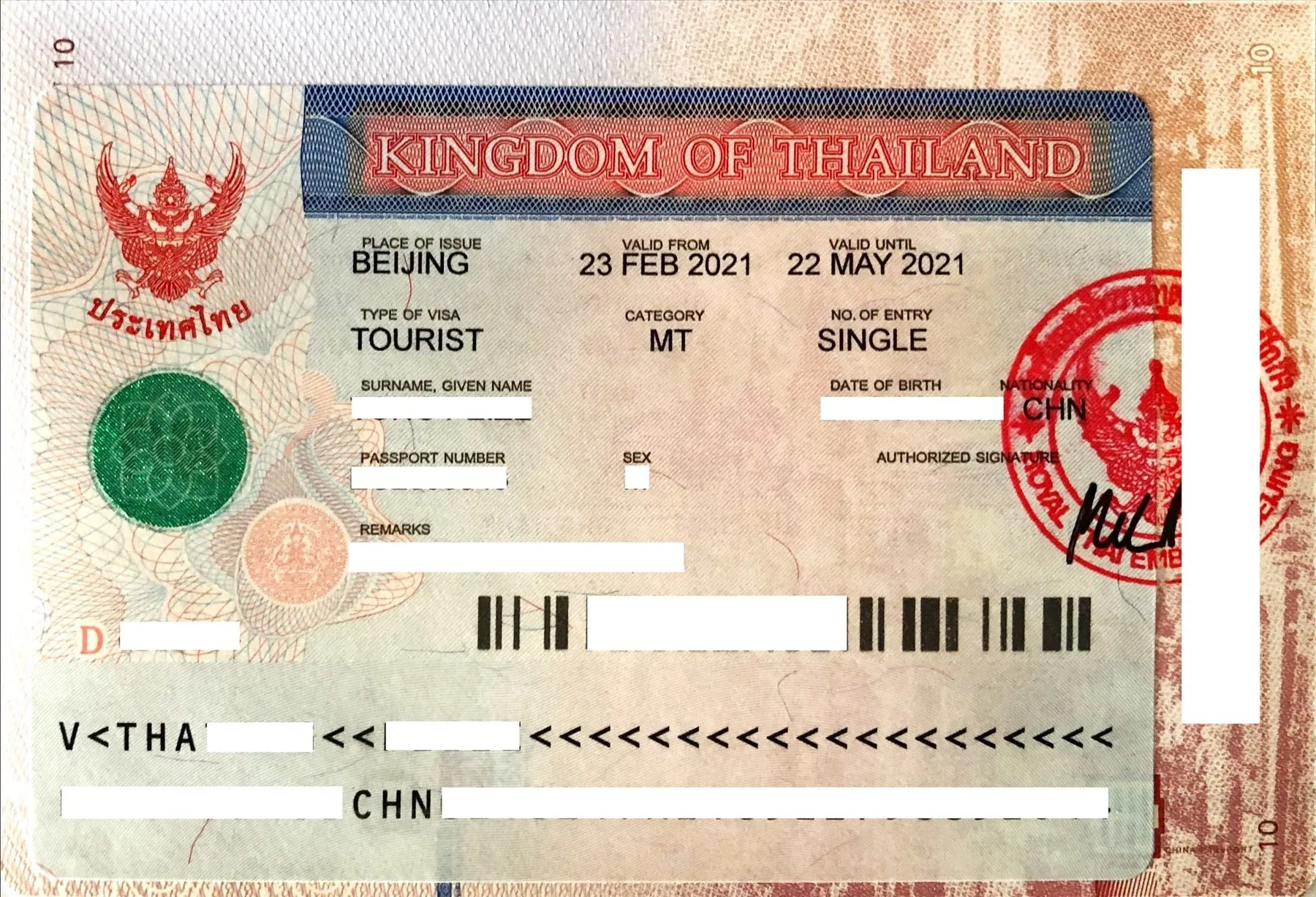 Thailandsk visum klæbet ind i et pas, med personoplysningerne sløret