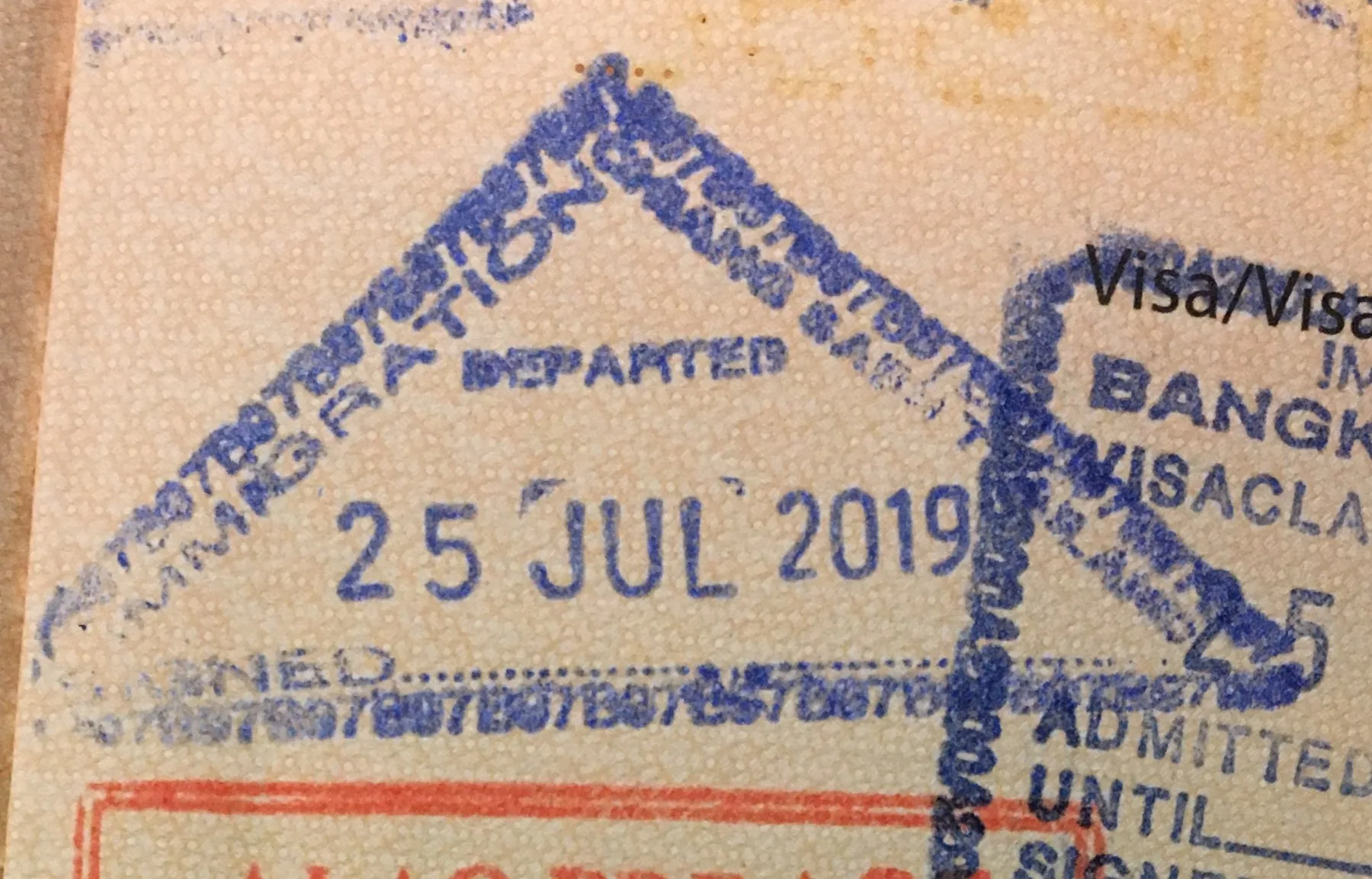 Thailandske utreisestempler med teksten Departed i et pass