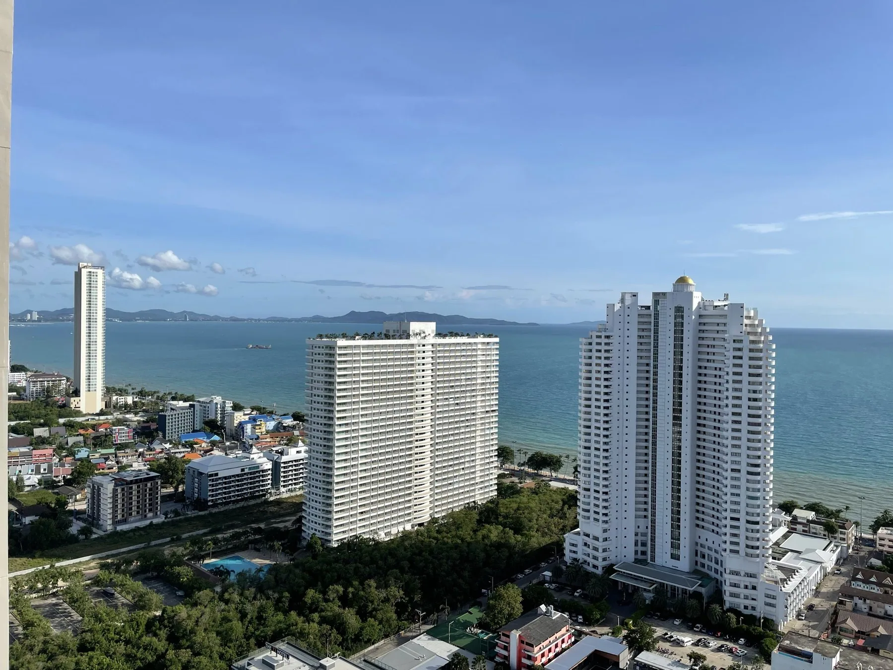 Bostadstorn och lägenhetshus längs kusten i Jomtien en klar dag