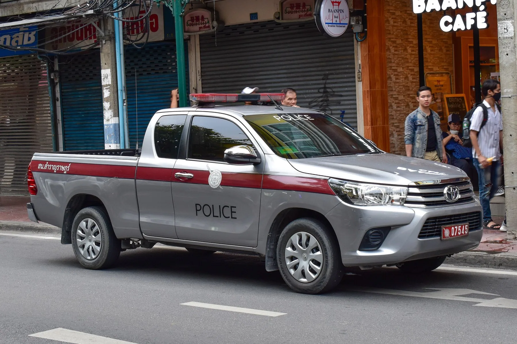 Grå pickup från thailändska trafikpolisen parkerad på en gata