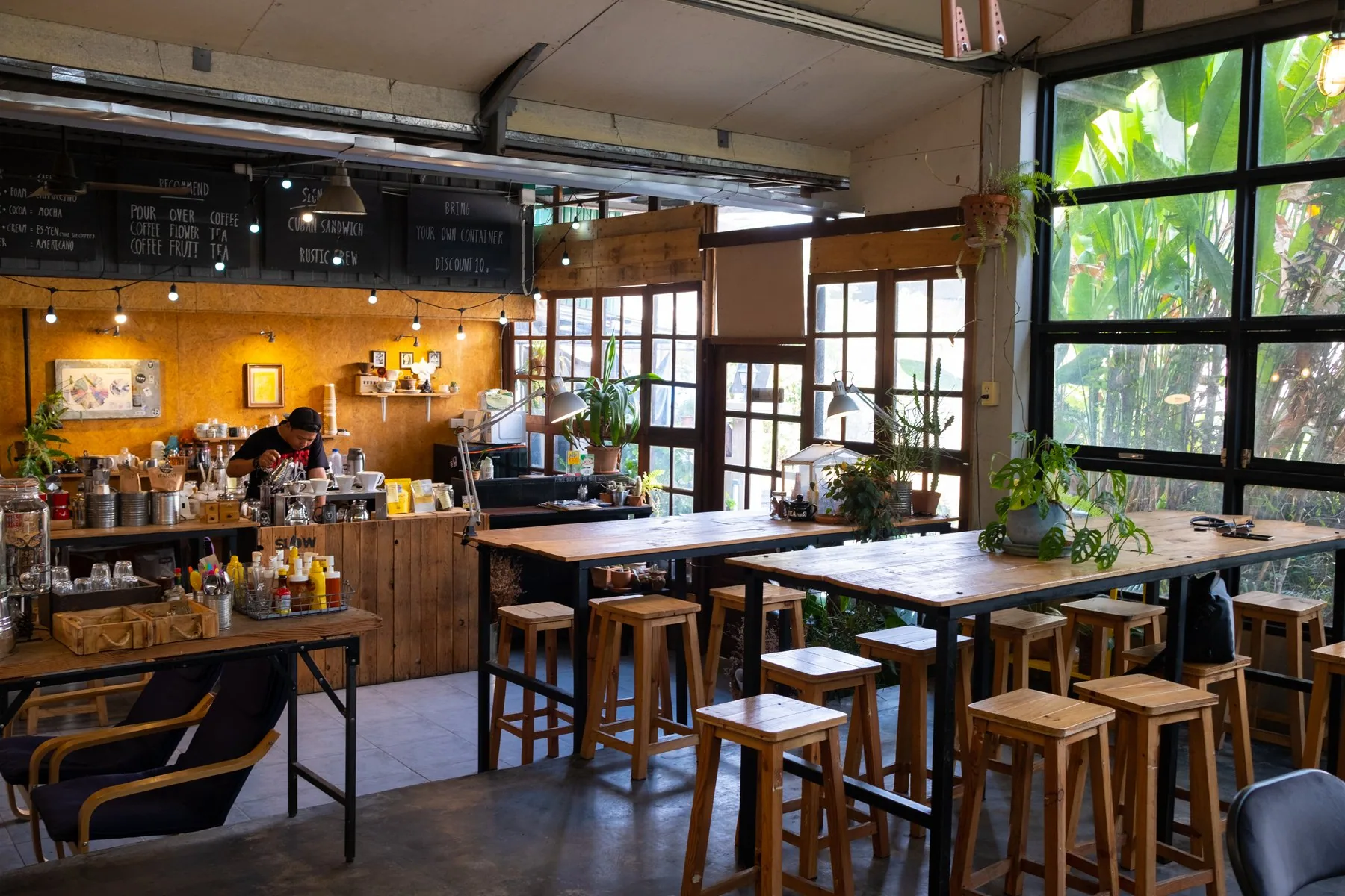 Lys café med træborde, skamler og baristadisk i Thailand