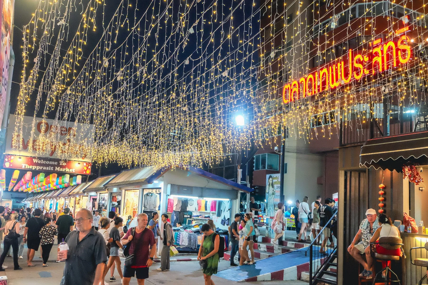 Lysslynger over bodene på Thepprasit nattmarked i Pattaya