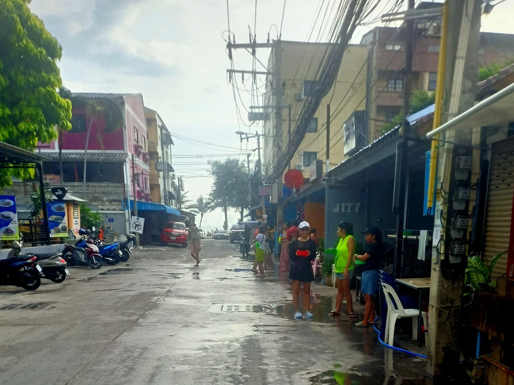 Folk med vannpistoler på en våt gate i Pattaya under songkran