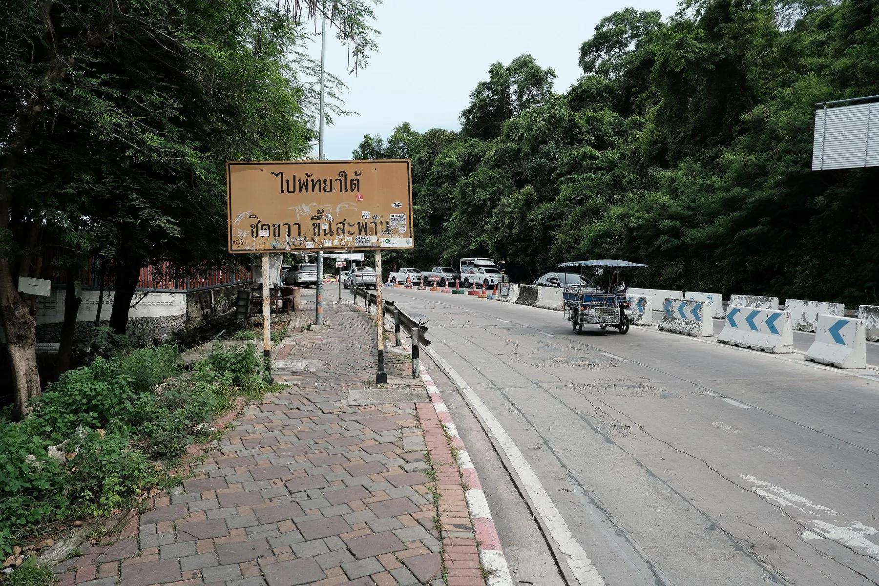 Snoet vej med thailandsk vejskilt mod det sydlige Pattaya