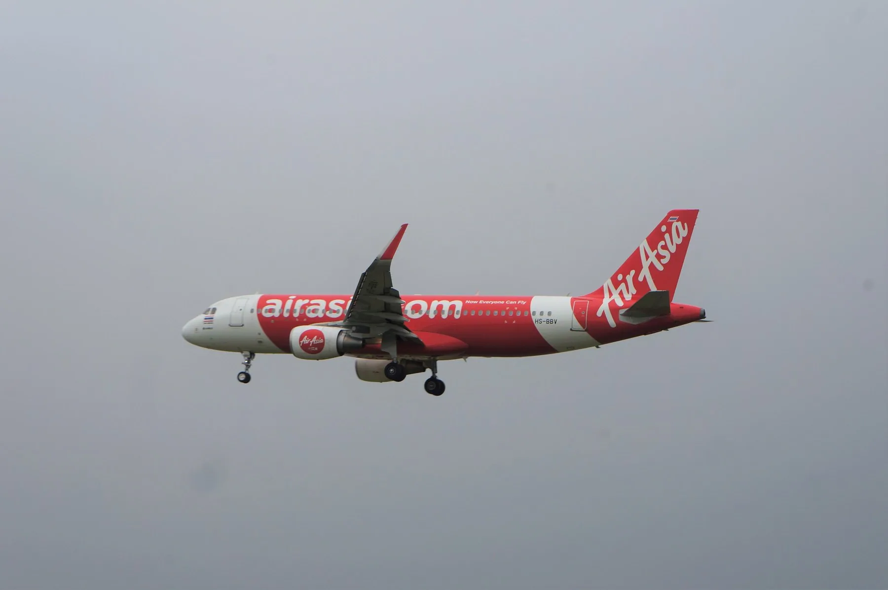 Rødt og hvidt Thai AirAsia-fly på vej ind til landing