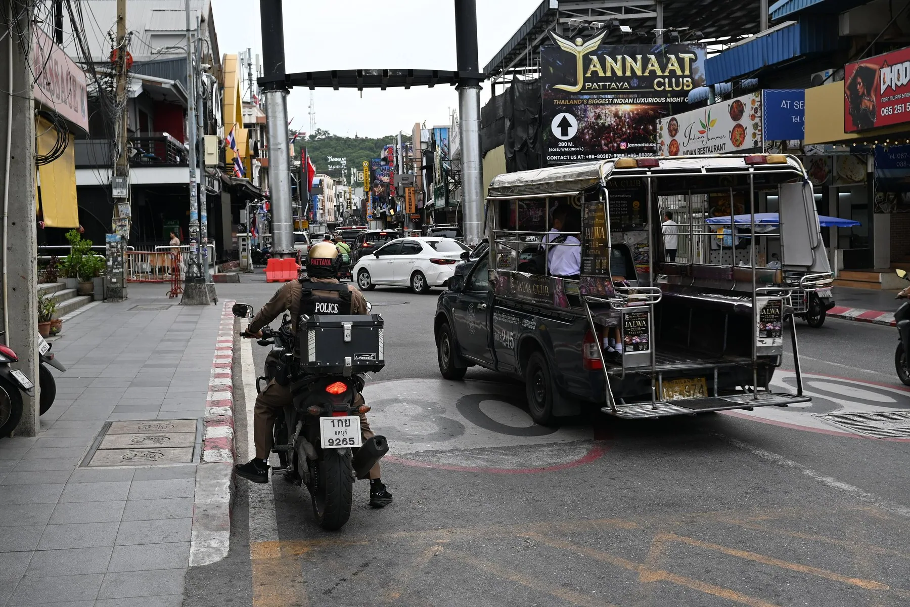 Baht-bus og motorcykler i en travl gade i Pattaya