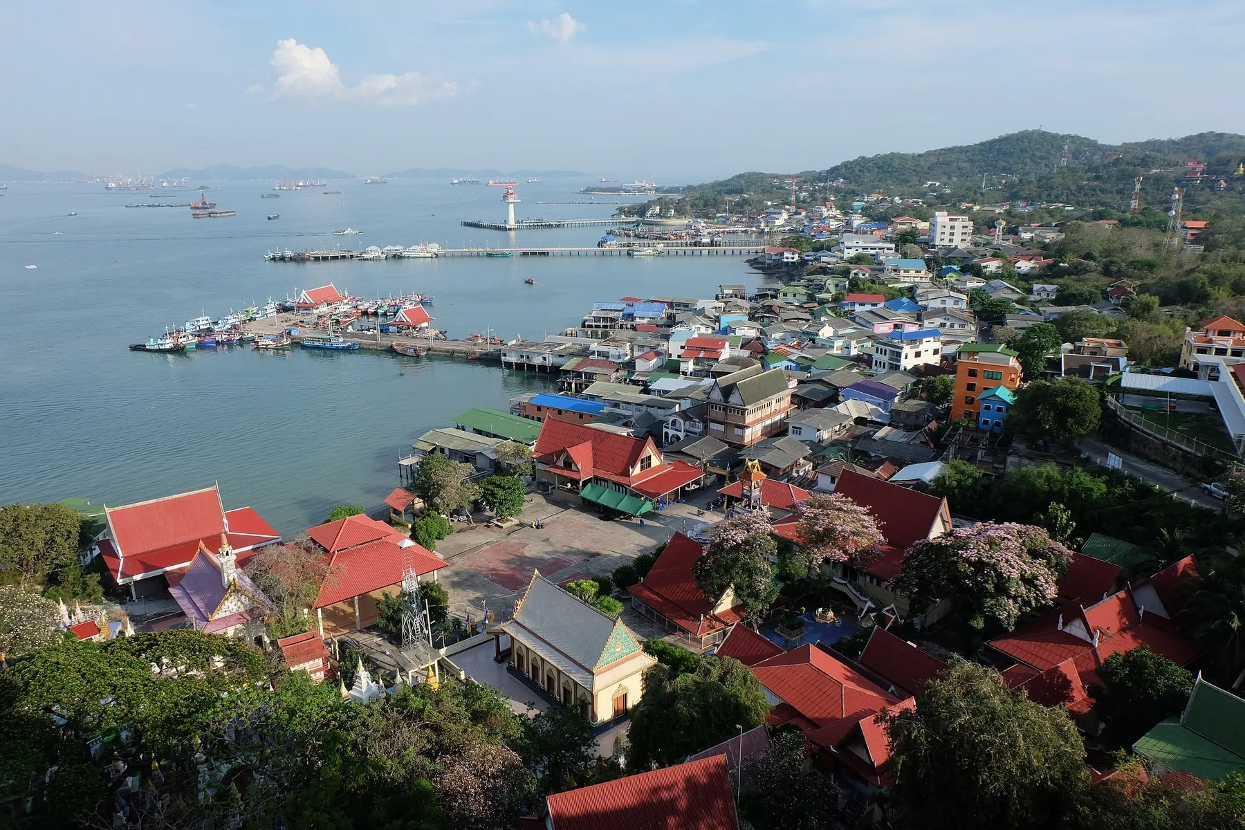 Udsigt over byen på Koh Si Chang med tempeltage, moler og fiskerbåde