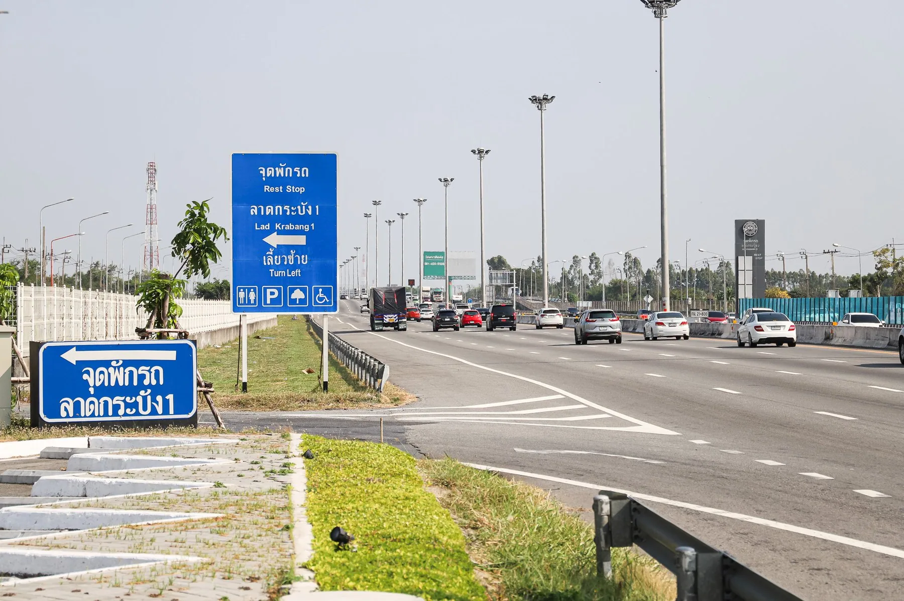 Blå vejskilte ved en rasteplads langs motorvejen øst for Bangkok