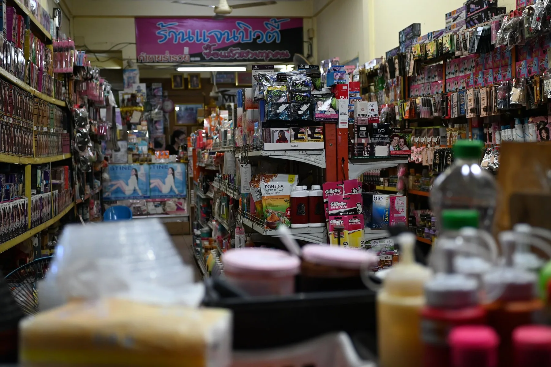 Smal butiksgång fylld med dagligvaror och hygienartiklar från golv till tak